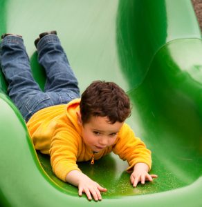 boy using therapeutic slide for postural control